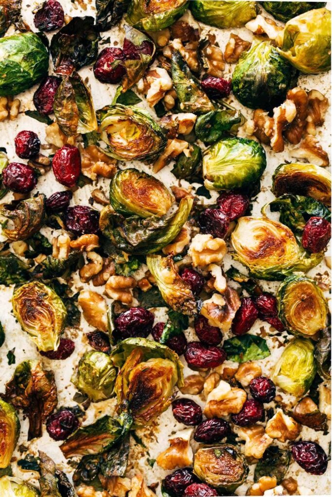 House Favorite Roasted Brussels Sprouts Recipe Close-up of Brussels sprouts on pan with walnuts and cranberries