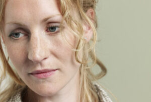 A woman looking thoughtful and a little bit sad.