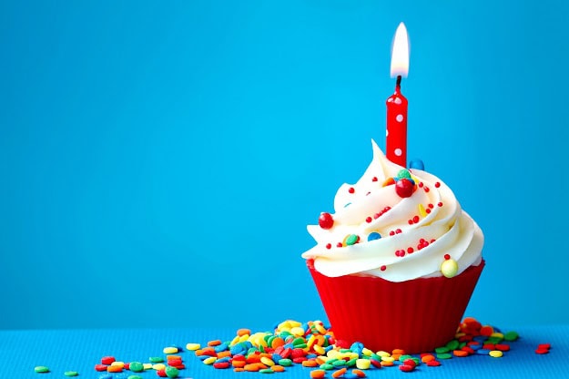 130 Happy Anniversary Quotes, Wishes and Messages for Couples and Cards A cupcake with a single lit candle in the middle of it.