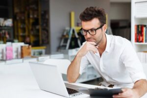 A focused and motivated man working on his laptop.