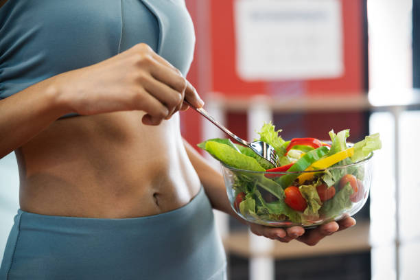 10 Effective Ways To Keep Your Stomach Healthy Effective Ways To Keep Your Stomach Healthy Close up of a sport woman with her sexy belly, she holding a bowl of fresh healthy food